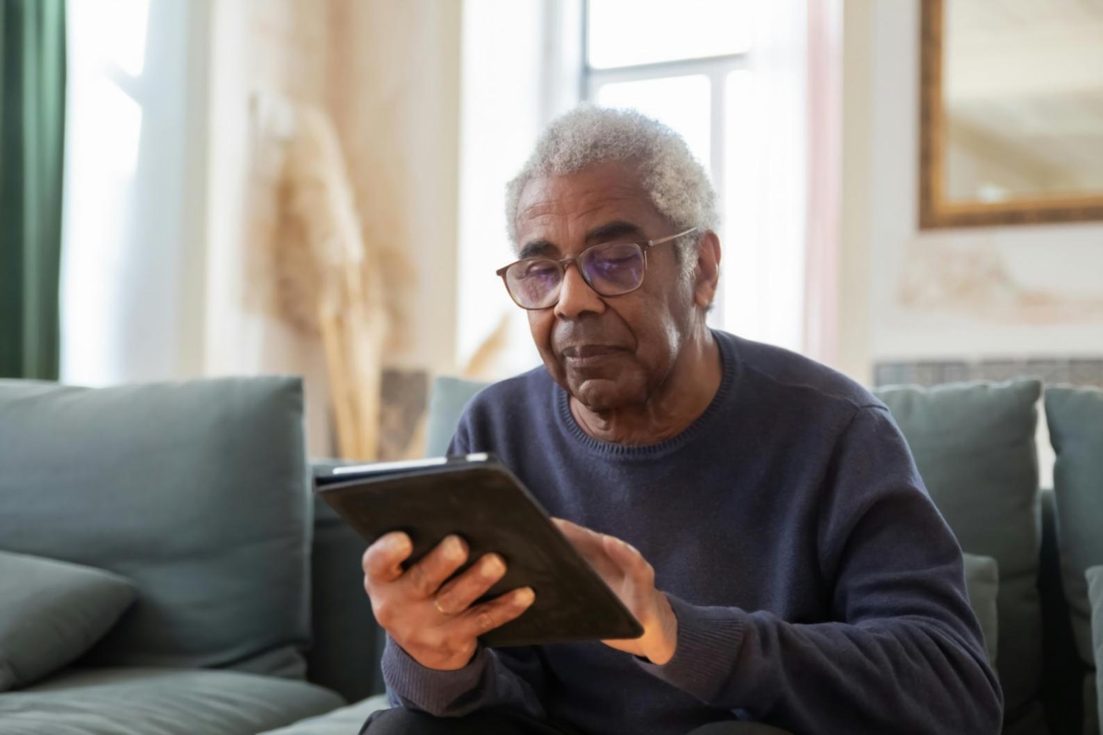 Professional caregiver assisting elderly client with daily activities in comfortable home environment