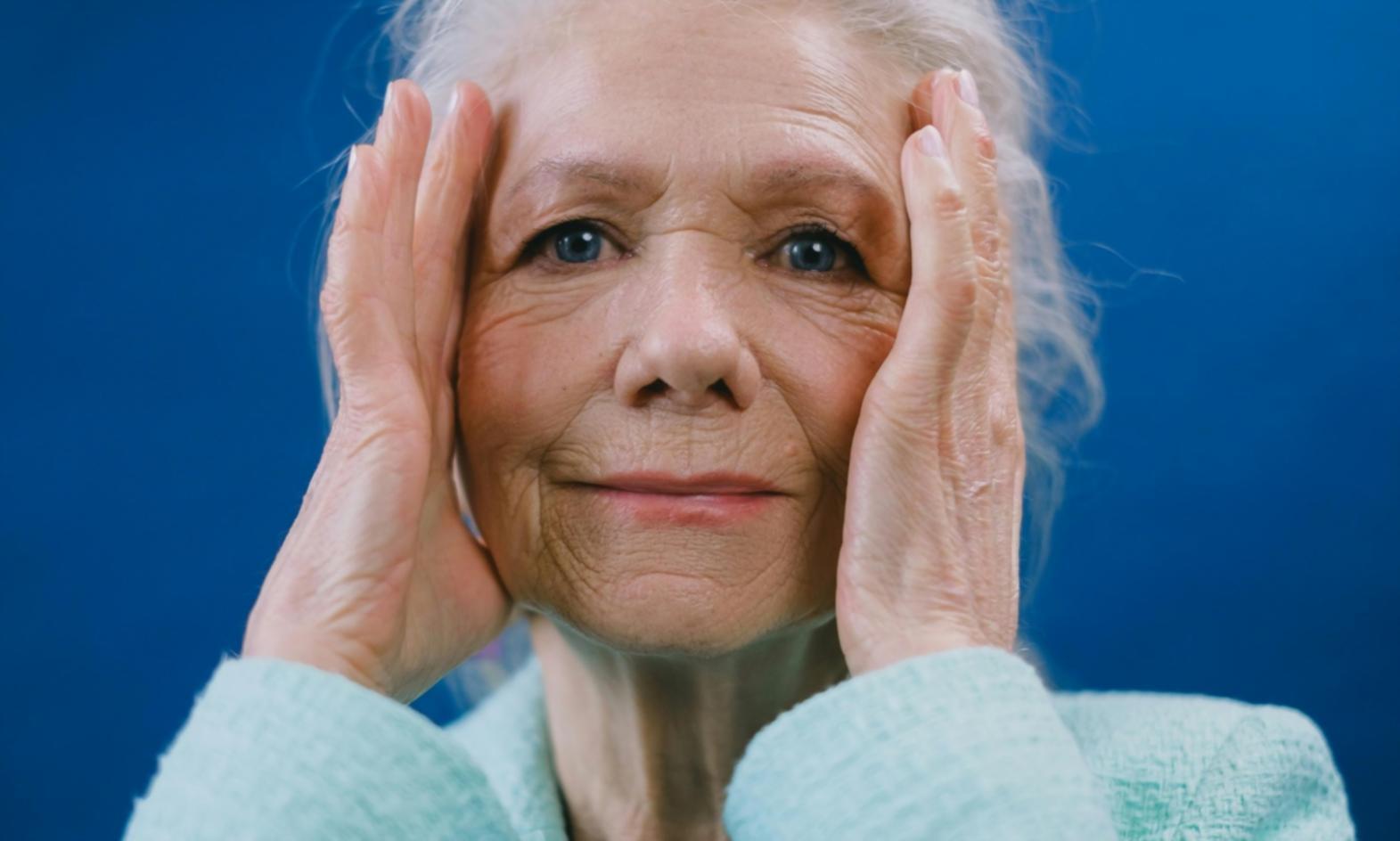 Care professional having friendly conversation with elderly client during home visit consultation